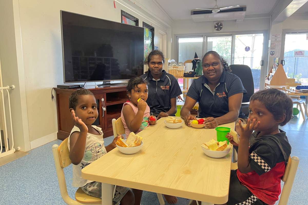 Creche staff and kids eating lunch