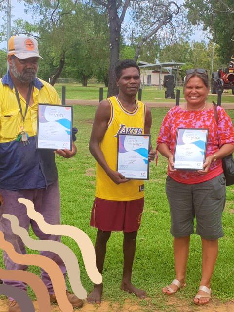 Three people holding certificates