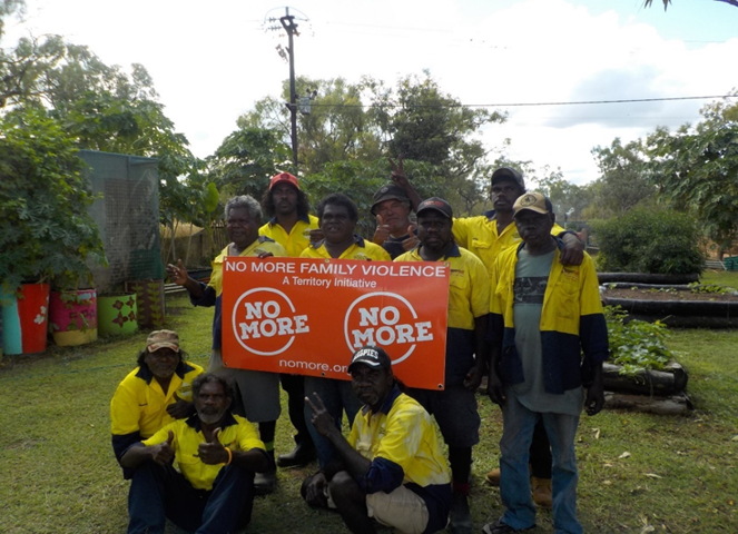 Group of CDP participants standing around a No More Violence sign