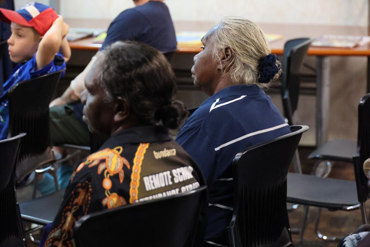 Two women sitting on black chairs 