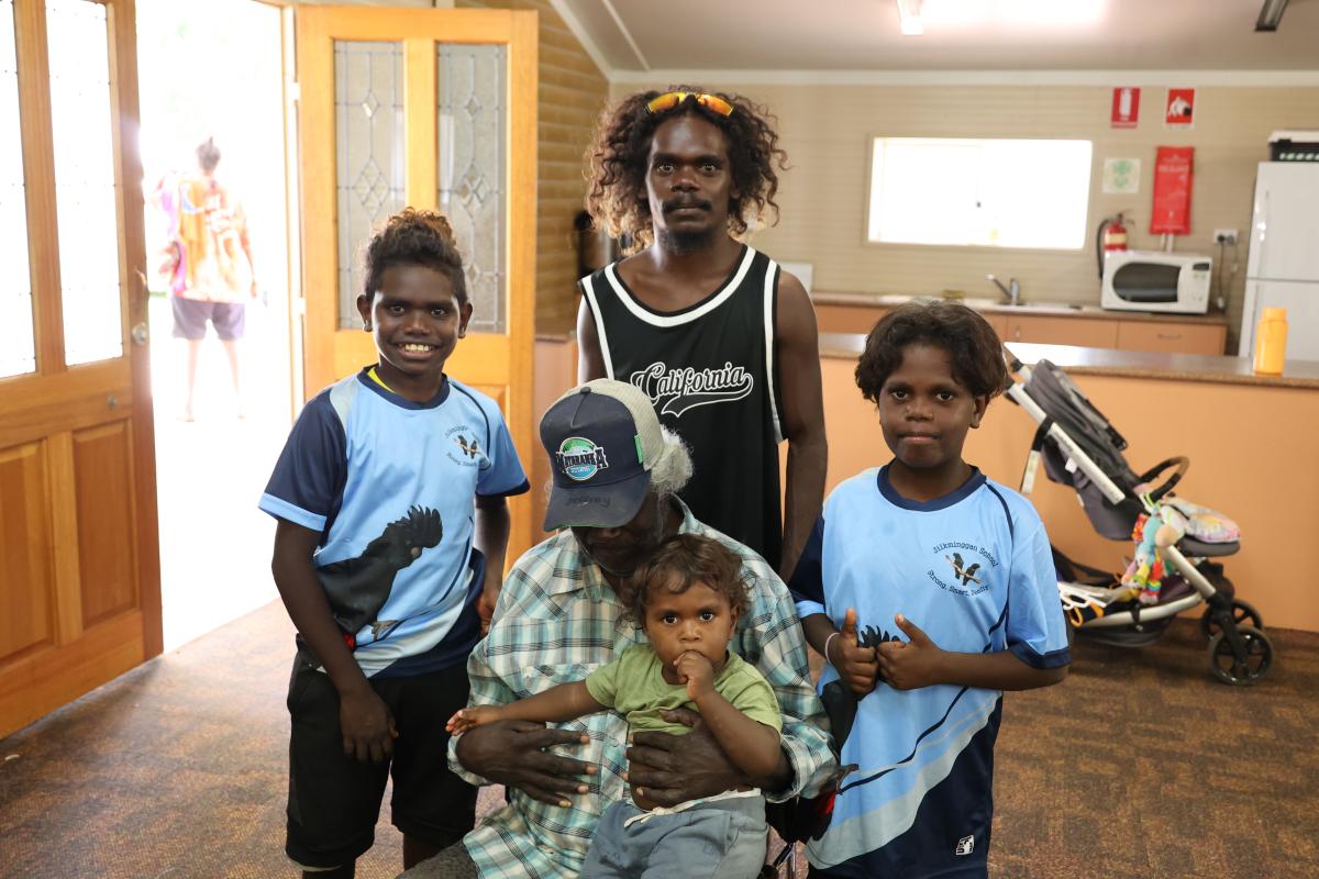 Grandparent with his 4 grandchildren standing around him