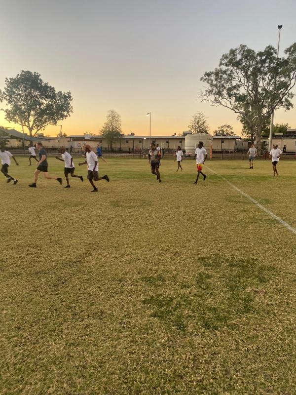 Youth playing soccer at dusk