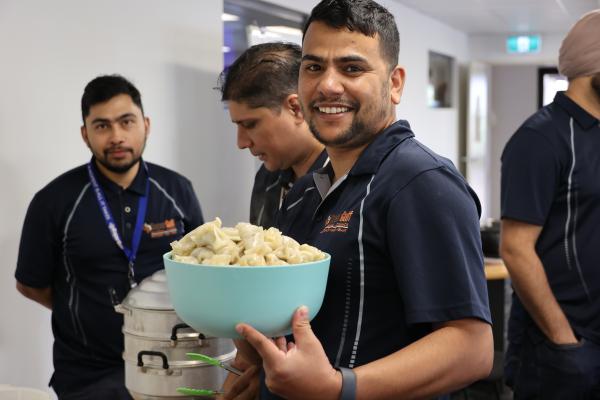 Man holding bowl of dumplings