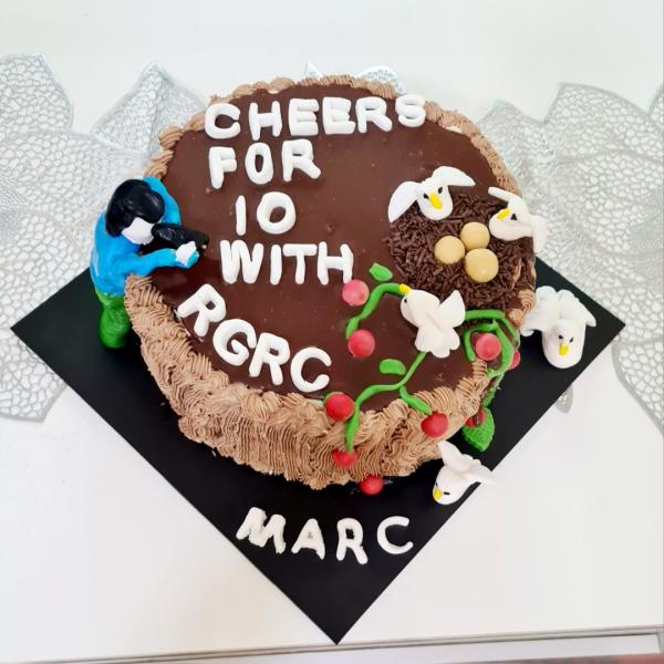 Brown cake with writing and sculptures on top