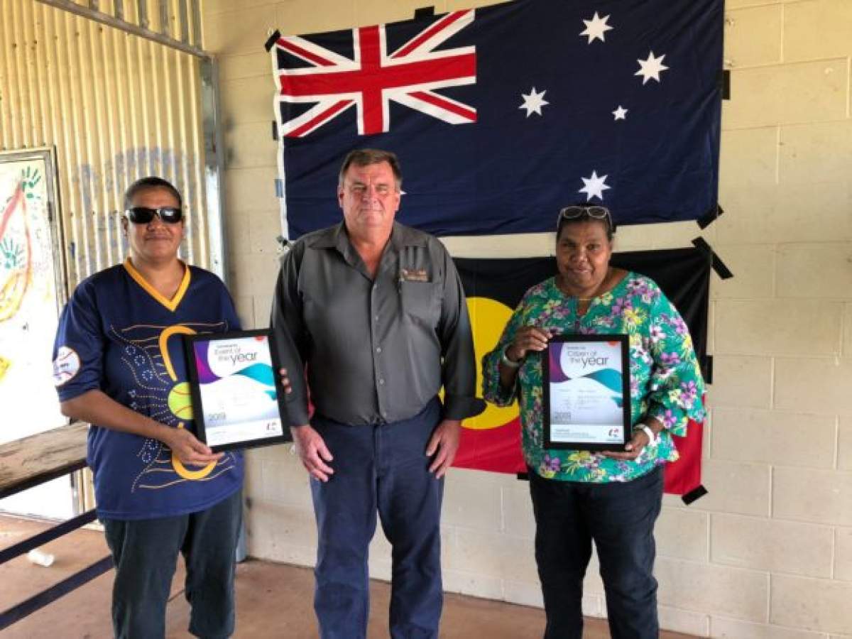 Three people standing in front of Australian Flag