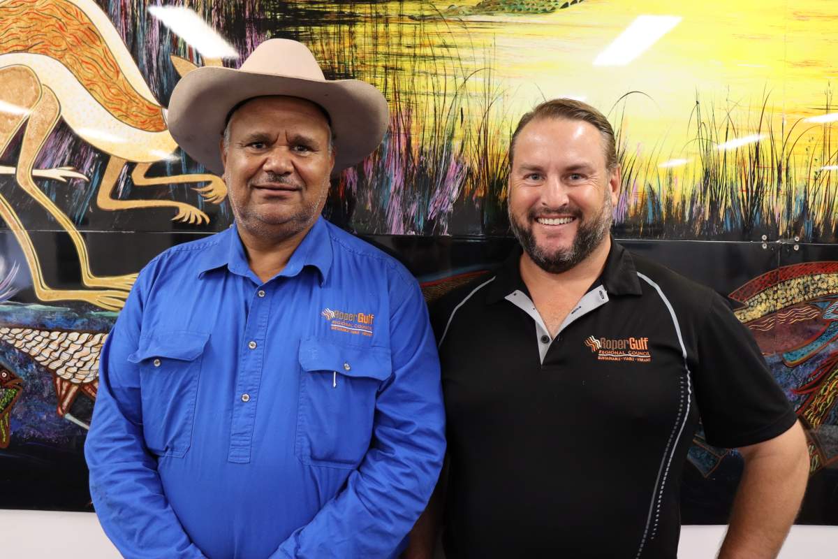 Mayor and CEO standing in front of painting smiling at camera