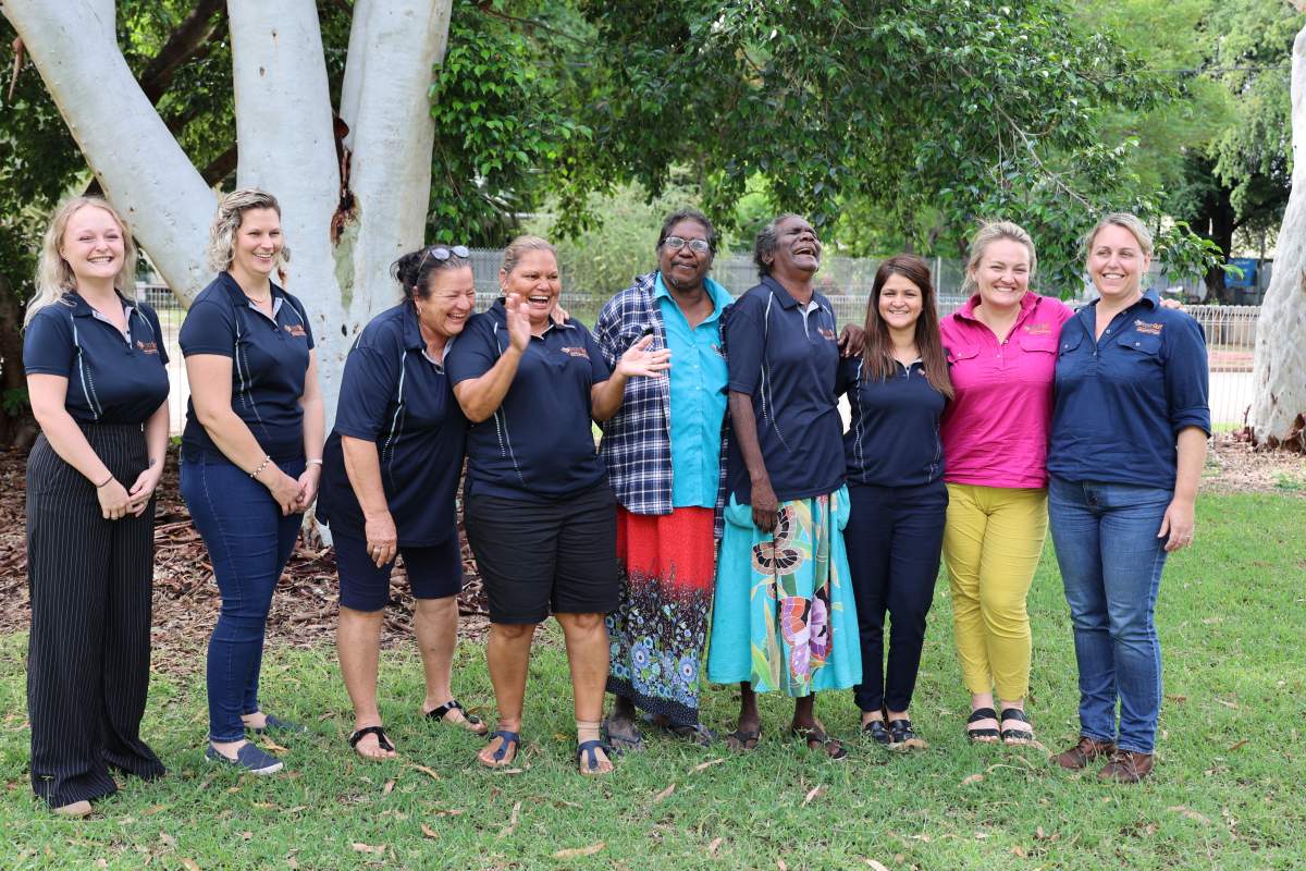 Women standing in a line outside laughing and smiling