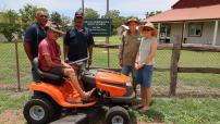 Staff from Borroloola Police Station museum standing around lawnmower 